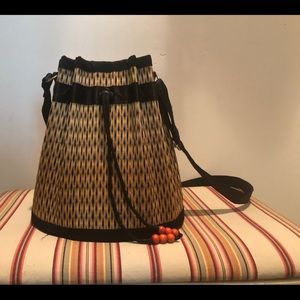 Crossbody bucket bag, basket weave, adj. strap.